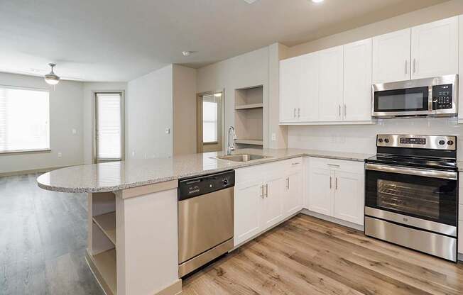 A kitchen with stainless steel appliances and white cabinets.