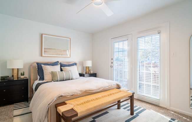 a bedroom with a large bed and two windows