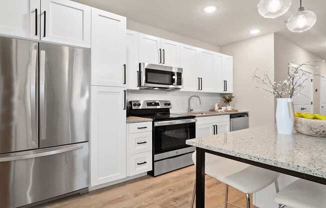 A modern kitchen with stainless steel appliances and white cabinets.