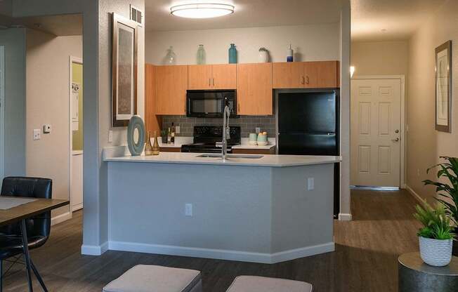A kitchen with a black counter top and a white island.