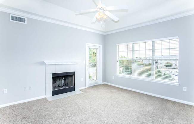 A living room with a fireplace and a ceiling fan.