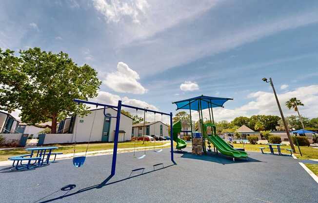 Community playground with slides and swings at Oasis at Bayside in Largo, FL.