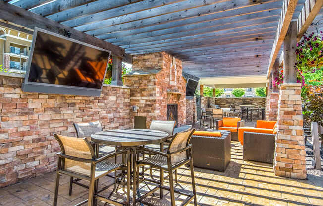 A patio with a table and chairs under a roof.