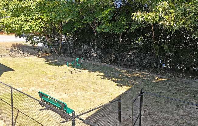 a park bench sitting in the grass next to a fence