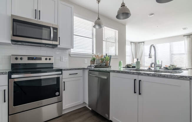 a kitchen with white cabinets and stainless steel appliances