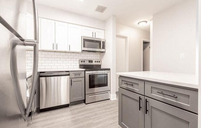 a kitchen with stainless steel appliances and white cabinets