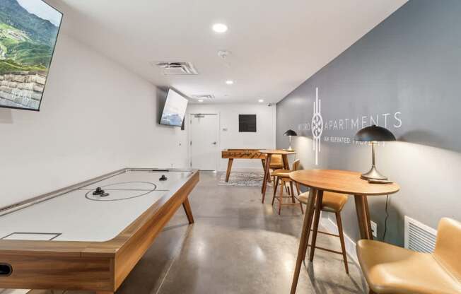 A room with a pool table and a TV mounted on the wall.