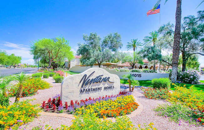 A sign for a Vine Park Apartment Homes is surrounded by flowers.