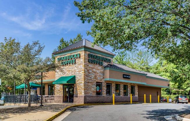 the facade of a restaurant with trees and a road