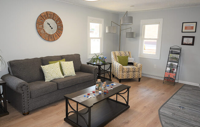 a living room with gray walls and a large clock on the wall