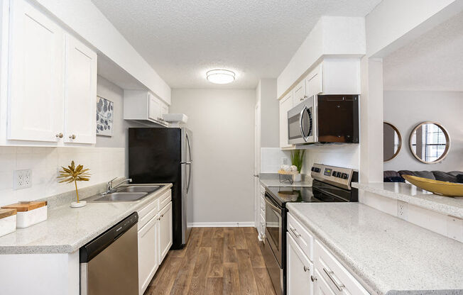 Renovated Galley Kitchen with White Cabinets and Stainless Steel Appliances