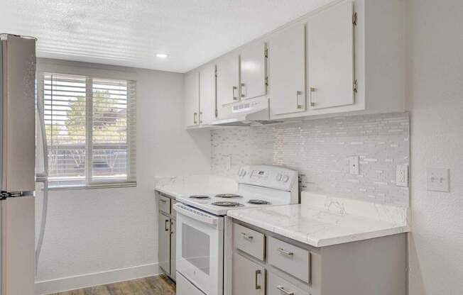A kitchen with white appliances and cabinets.