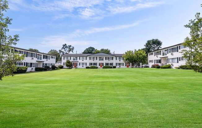 the view of a large green lawn in front of apartment buildings