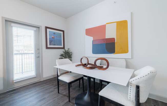 a dining room with a white table and chairs and a window