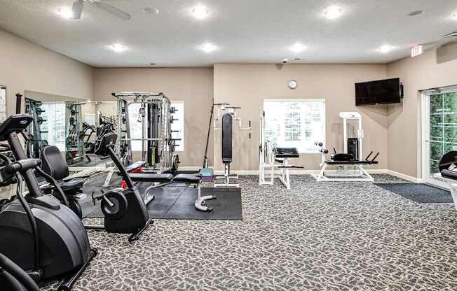 A spacious gym with a variety of equipment including treadmills, elliptical machines, and weight machines. at Tranquility Pointe, Nebraska, 68164
