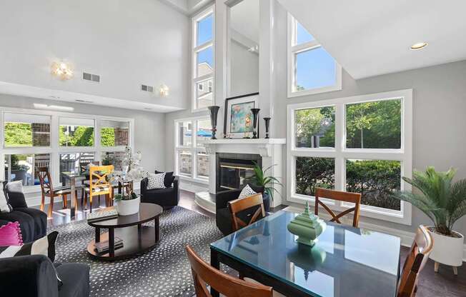 A modern living room with a glass table and black and white patterned rug.