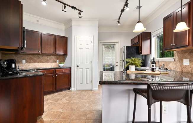 a kitchen with brown cabinets and a counter top at Sovereign at Overland Park, Kansas, 66213