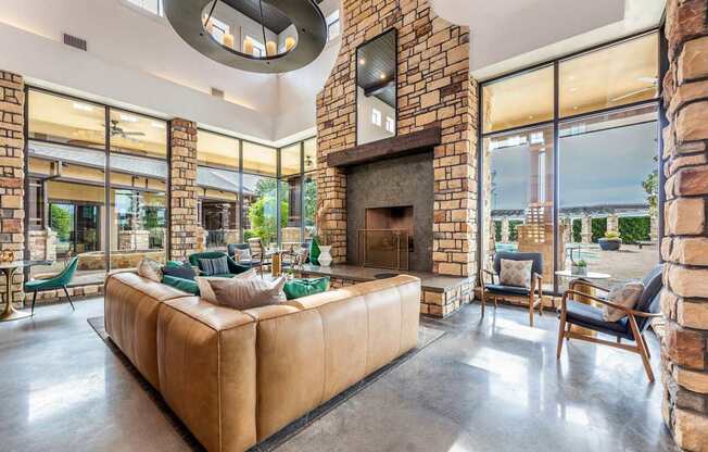 A living room with a stone fireplace and a large couch.