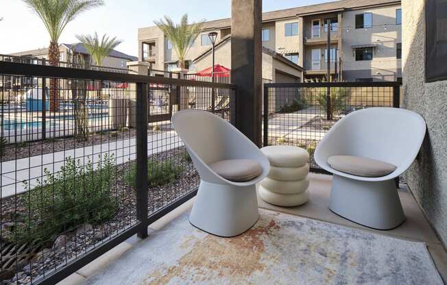 two toilets sitting on a balcony next to a fence
