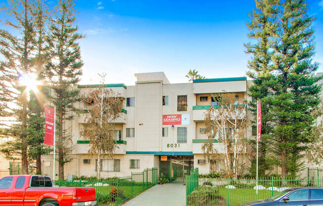 a white apartment building with green trim and a red sign that reads 801