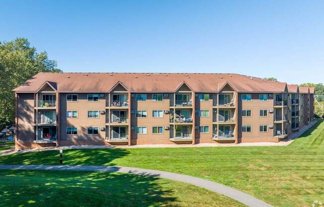 a large building with a green lawn in front of it