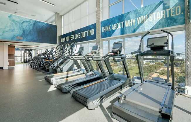 A gym with treadmills and a sign that says