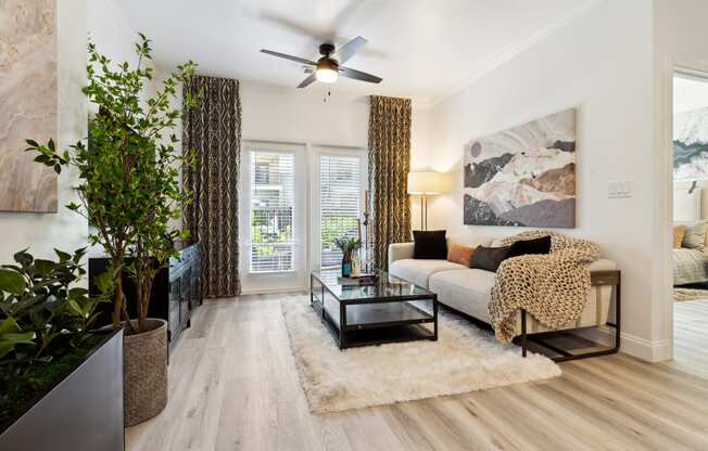 a living room with hardwood floors and a ceiling fan