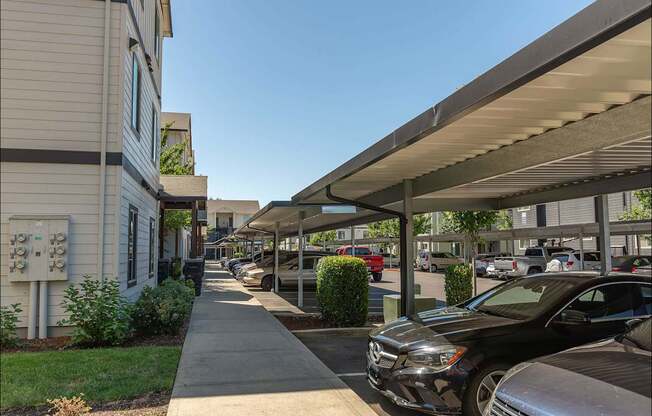 A parking lot with cars and a building in the background at Forestplace Apartment Homes, Forest Grove