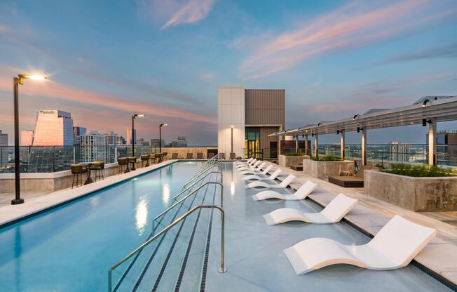 Rooftop pool with skyline views, streamlined loungers, and sunset backdrops designed for unwinding, social time, and evening swims.