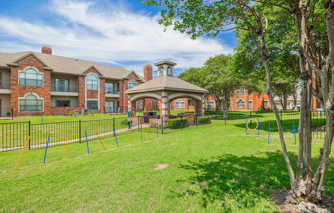 A large grassy area in front of a brick building with a playground.