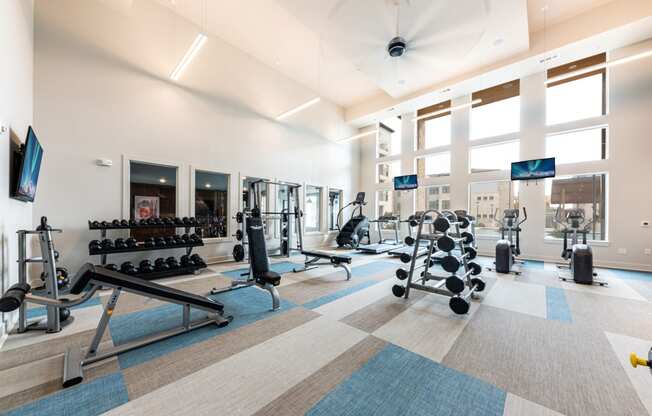 Lenox SoCo Apartments  spacious fitness center with weights and cardio equipment in a building with large windows