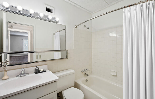 Model Master Bathroom with White Cabinets and Wood-Style Flooring at Elevate on Parkway, Burnsville, Minnesota, 55337