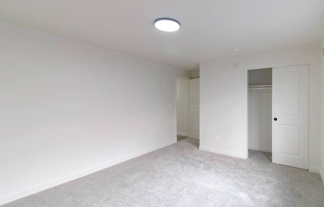Carpeted bedroom with ceiling light at Melrose on 91 apartments Redmond
