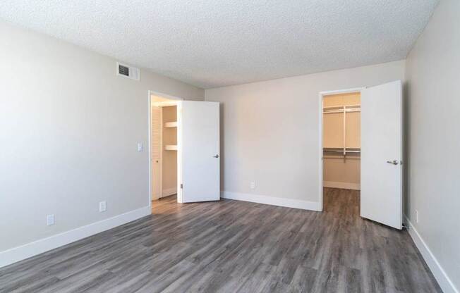 A room with a wooden floor and two white doors.