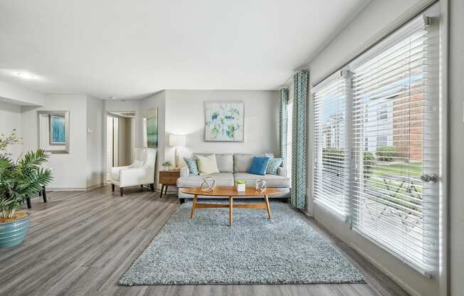 A living room with a couch, chairs, and a rug.