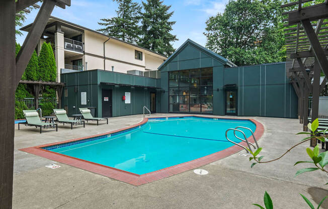 A small pool in a backyard with a wooden pergola.