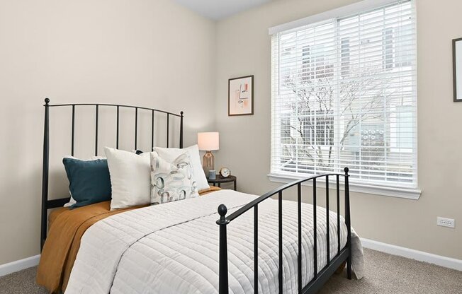 bedroom with a wrought iron bedframe and large window