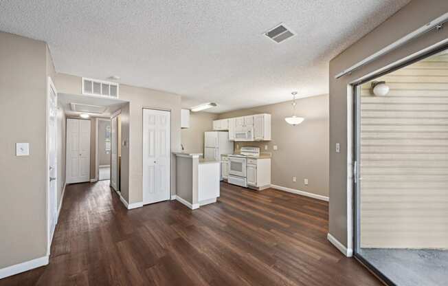 an open living room and kitchen with a sliding glass door