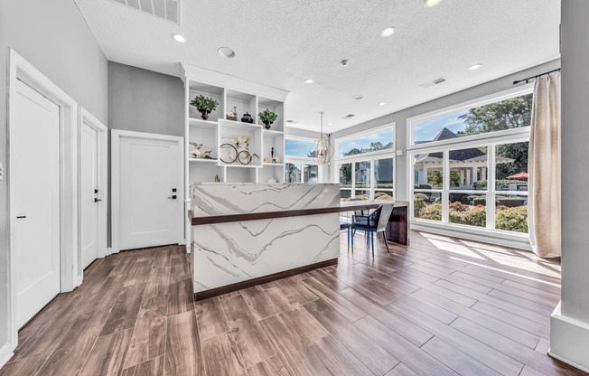 a kitchen with a marble counter top and a large window