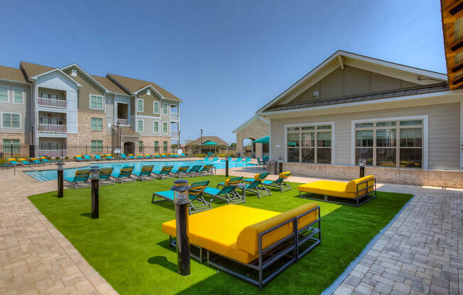 a resort style pool with lounge chairs and grassy area