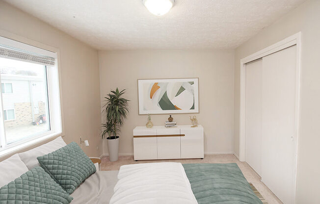 a bedroom with a large bed next to a window