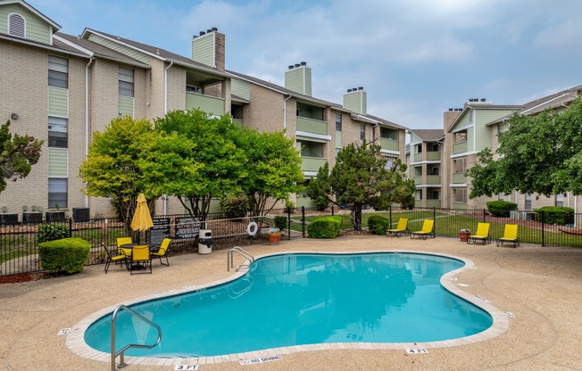 our apartments have a swimming pool and a patio with yellow chairs