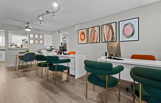 A room with a desk, chairs and pictures on the wall.