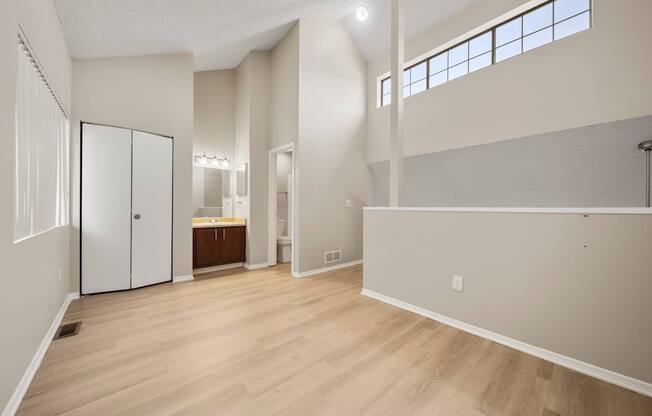 A large empty room with wooden floors and white walls.