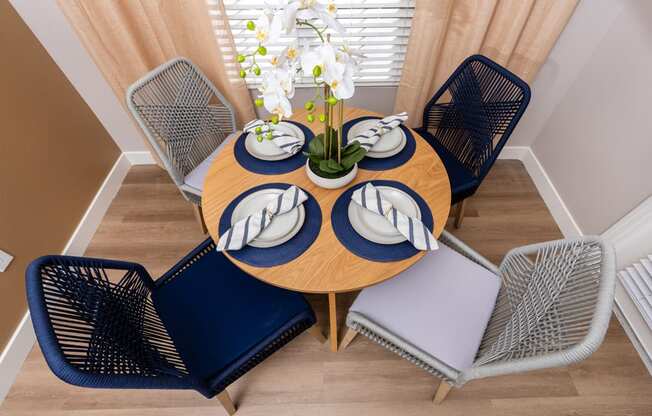 a dining room with a wooden table with blue chairs and a blue and white table