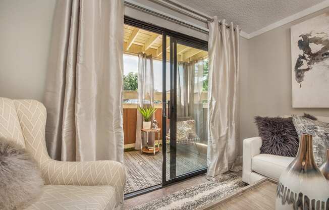 a living room with a sliding glass door to a patio at Lodge of Overland Park Apartments, Overland Park