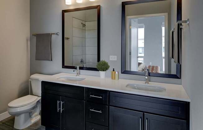 A bathroom with a white sink and black cabinets.