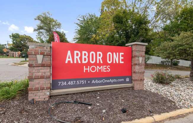 a sign that reads arbor one homes in front of a street