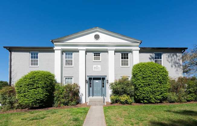 the front of a white house with a blue door