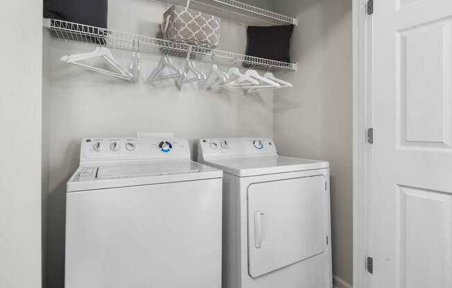 Two white front loading washing machines in a laundry room.